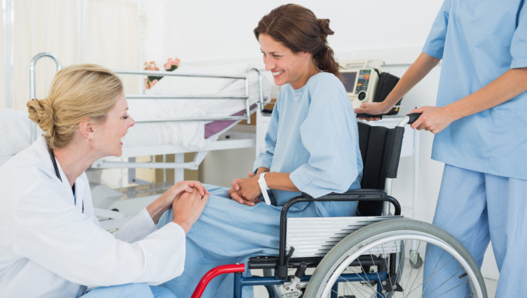 Un médecin parle à un patient en fauteuil roulant à l'hôpital